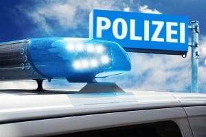 Polizeifahrzeug vor Polizeischild